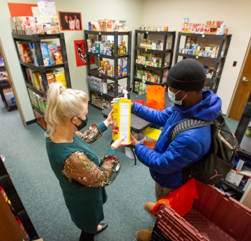 Ms.Helling working with student in Milligan's Food Pantry at Buffalo State